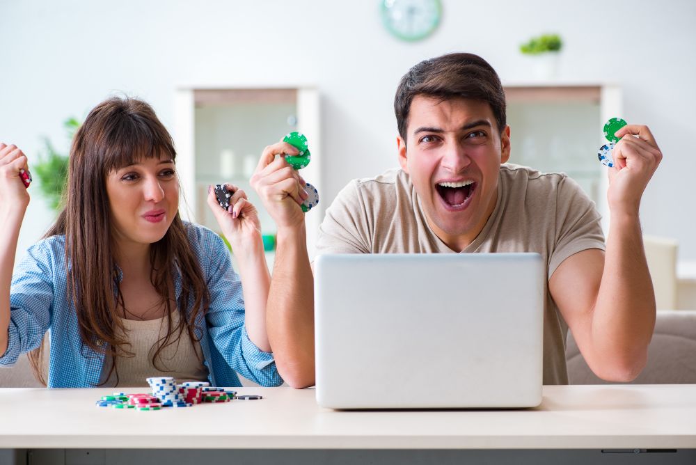 パソコンを見ながら喜ぶカップル
